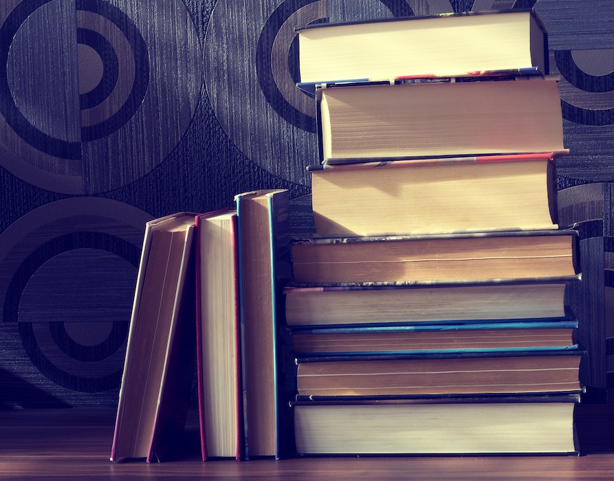 A stack of books with a few books on their side